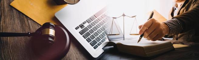 Business and lawyers discussing contract papers with brass scale on desk in office. Law, legal services, advice, justice and law concept picture with film grain effect photo