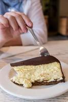 comer una tarta de queso en una tienda de delicatessen foto