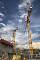 Day view of the construction site with cranes and building. Vertical view photo