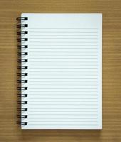 blank spiral notepad on wood background photo