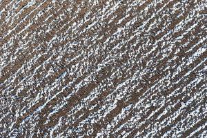 The plowed field in winter. Fields covered with snow. View from the top. photo