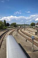 vías férreas y tren en movimiento cerca de la estación de tren. vista vertical foto