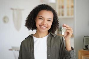 Smiling mixed race teen girl tenant or homeowner holds keys to new home. Rental housing, mortgage photo