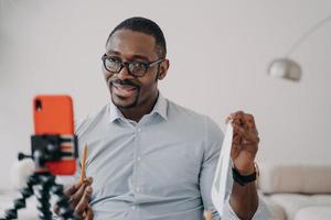 African american businessman discussing business project online by video call, using smartphone photo