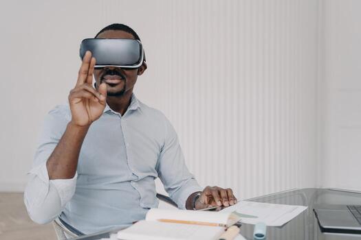 African american man architect in VR glasses working on project in virtual reality at office desk photo