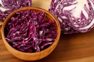 Purple cabbage is in a wooden bowl ready to make a salad.