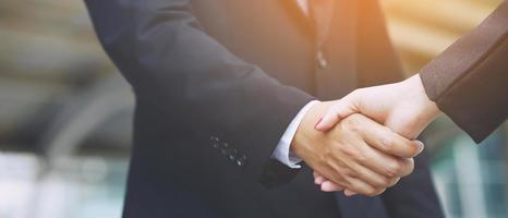 Closeup of a businessman hand shake businesswoman between two colleagues  OK, succeed in business Holding hands. photo