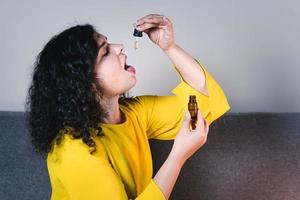 mujer adulta usando y sosteniendo aceite de cannabis medicinal. cdb foto