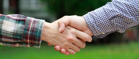 Closeup of a business hand shake between two colleagues Plaid shirt photo
