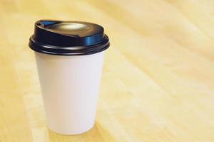 paper coffee cup color white on on table top at cafe. wooden background photo