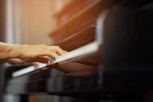 close up of hand people man musician playing piano keyboard with selective focus keys. can be used as a background. photo