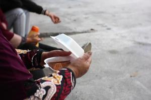 alguien lleva una caja blanca de comida foto