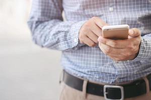 cerrar la mano de un joven que usa un teléfono móvil inteligente. foto