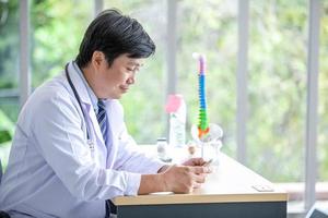 doctor with stethoscope using smartphone in office. photo