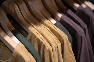 enfoque selectivo, moda, concepto de ropa, ropa o pantalones de muchos colores colgados en un estante en una tienda de ropa de diseñador. muchos colores pastel foto