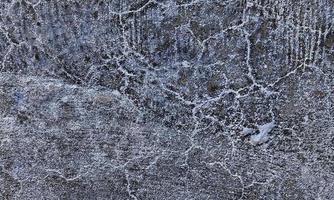 Old Wall damaged with blown Plaster and paint clog,peeling paint damage,water damage on building wall.Grunge abstract background.Wall fragment with scratches and cracks.Old distressed wall backdrop. photo