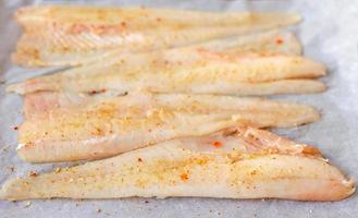 Delicious fresh fish hake fillet with spices and herbs photo