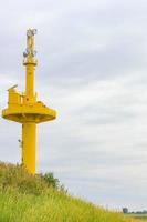 Nordenham Lower Saxony Germany 2010 Yellow Lighthouse dyke dike mudflat waves landscape coast Nordenham Germany. photo