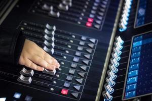 Close up of child adjusting sound on digital audio mixer. photo