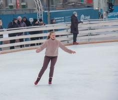 People have fun skating on a public ice rink built by the municipality on the streets of the city during Christmas photo