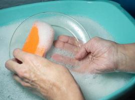 Hand washing dishes. Washing the plate with a foam sponge photo