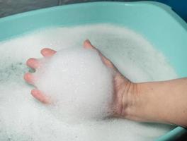 Foam in hand. Washing dishes. Washing basin. photo