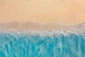 paisaje marino de verano hermosas olas, agua de mar azul en un día soleado. vista superior desde el dron. vista aérea del mar, increíble fondo de naturaleza tropical. hermosas olas de mar brillantes salpicando y arena de playa luz de puesta de sol foto