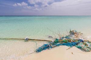 The problem of trash on the beach caused by man made pollution and environmental in concept. Tropical island beach, outdoor vacation with pile of trash and rubbish. Plastic on beach, ecology danger photo