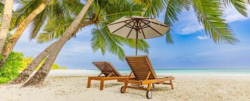 Beautiful panoramic nature. Tropical couple beach as summer island landscape with chairs umbrella palm leaves calm sea shore, coast. Luxury travel panoramic destination banner for vacation or holiday
