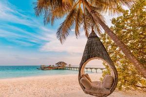 Tropical beach sunset as summer landscape with luxury resort beach palm swing hammock, sand seaside shore for sunset beach landscape. Tranquil beach horizon scenery vacation and summer holiday concept photo