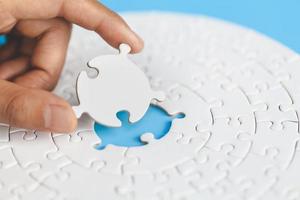 White jigsaw in the hands of humans, The correct solution. Teamwork, Solving and completing the task. Last piece of jigsaw puzzle. Assembling  jigsaw puzzle pieces. photo