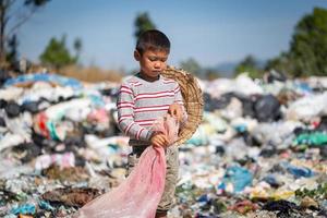 los niños pobres recogen basura para la venta y la reciclan en vertederos, la vida y el estilo de vida de los pobres, el trabajo infantil, la pobreza y los conceptos medioambientales foto