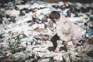 Children find junk for sale and recycle them in landfills, the lives and lifestyles of the poor, Child labor, Poverty and Environment Concepts photo