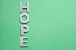 hope word with wooden letters on the green background photo