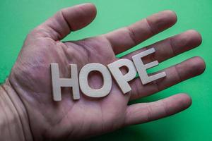 hope word with wooden letters on the green background photo