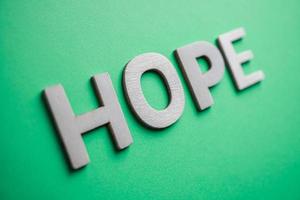 hope word with wooden letters on the green background photo