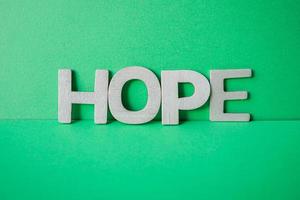 hope word with wooden letters on the green background photo