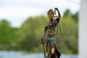 Statue of Themis against a nature background. Symbol of justice and law, crime and punishment. photo