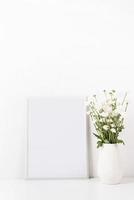 White frame mockup with chrysanthemum flowers in a vase on a white table photo