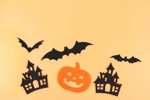 decorations for Halloween holiday, Halloween pumpkins, castles and bats on orange color background. photo