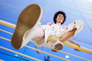 Optimistic black woman sitting on fence photo