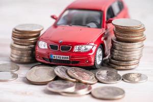 bangkok, tailandia, 1 de junio de 2022 coche en pila de monedas. Préstamo de automóvil, finanzas, ahorro de dinero, seguros y conceptos de tiempo de arrendamiento. foto