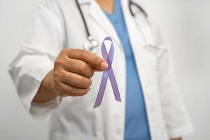 Asian woman doctor with purple ribbon, sign of Alzheimer disease day, Pancreatic cancer, Epilepsy, Lupus. photo