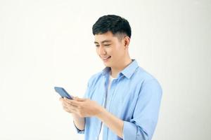 Attractive young man with smartphone on white background photo