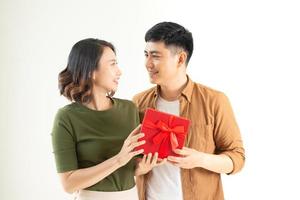 Hermosa joven pareja con presente aislado sobre fondo blanco. foto