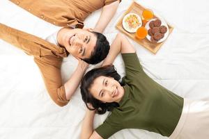 Cute couple having breakfast in bed in the bedroom. photo