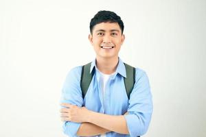 Young man standing crossed arms wearing backpack on a white background. photo