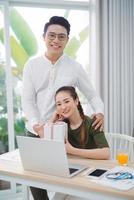 businessman giving gift box to woman in office photo