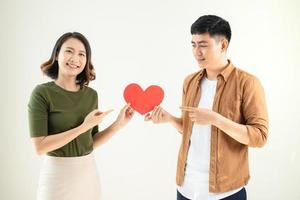 Young Asian couple holding a heart sticker photo