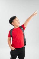 Smiling school boy with backpack pointing at you, isolated on white background photo